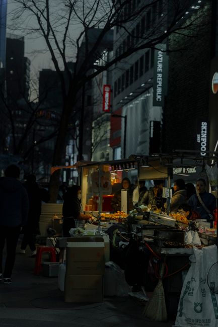 Mercado de comida callejera en Corea del Sur con puestos iluminados